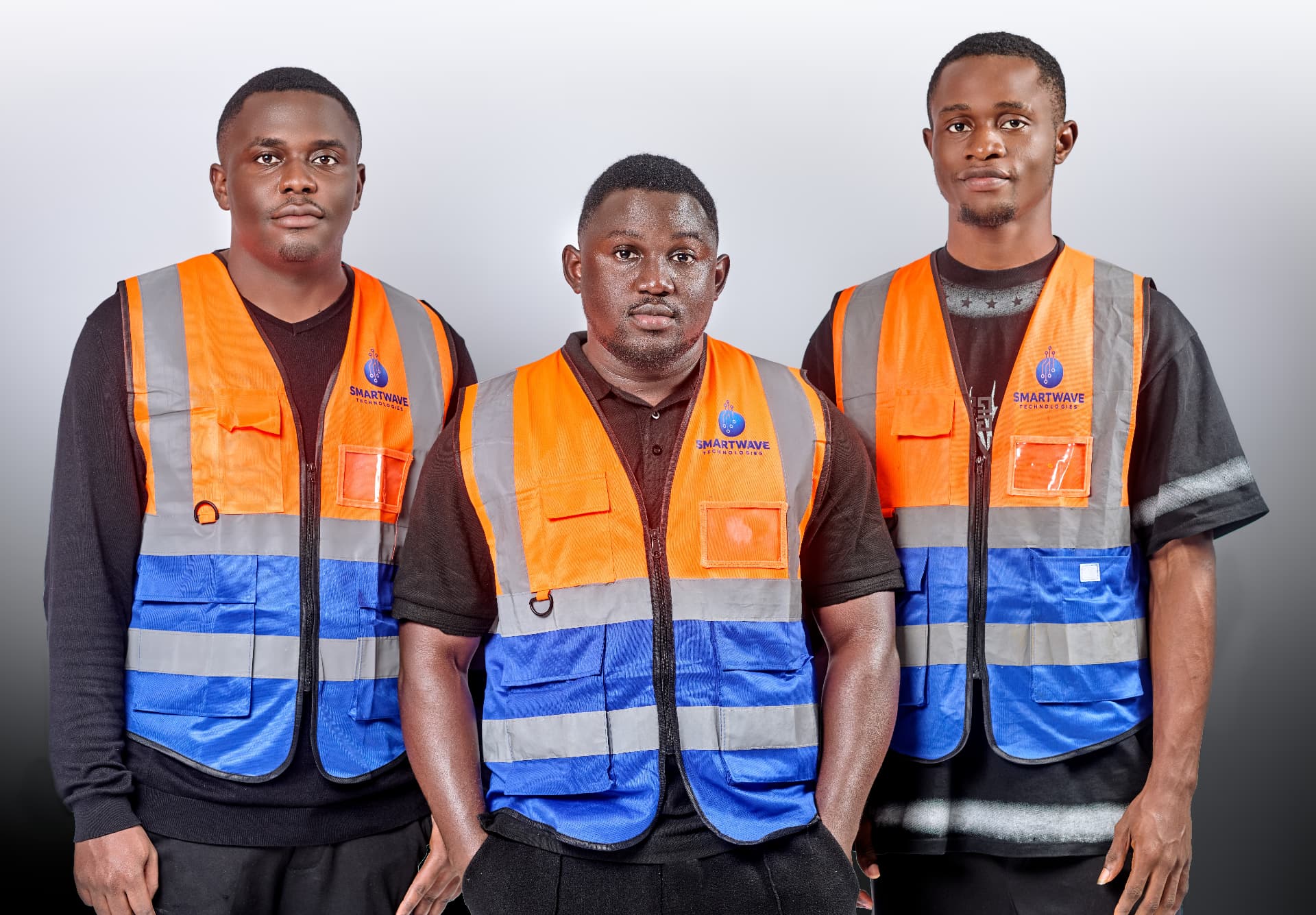 Three Smart Wave Technologies engineers in branded high-visibility vests