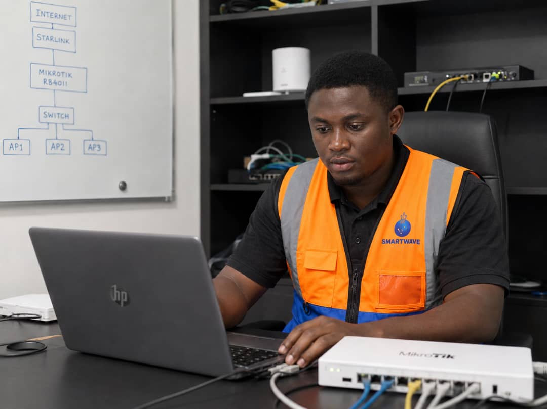 Smart Wave Technologies engineer configuring a MikroTik router for a business network in Cameroon