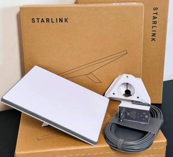 Starlink Mini dish, tripod mount and cable in front of original Starlink boxes